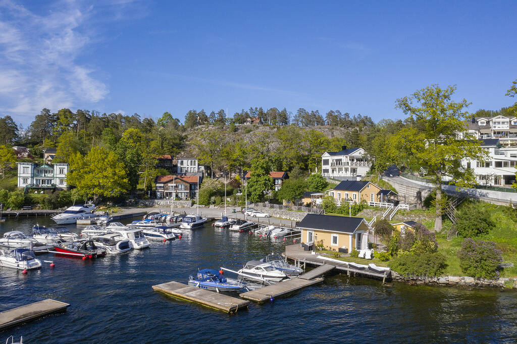 Skärgårdsmarina med motorbåtar vid brygga en sommardag